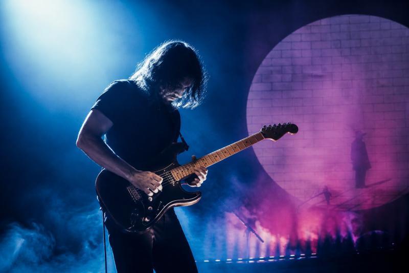 Gitarrist spielt emotionales Solo von Comfortably Numb unter blau-violettem Licht
