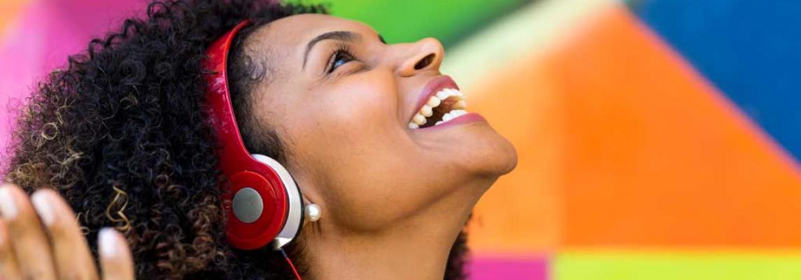 Junge Frau hört bunte Popmusik mit Kopfhörern