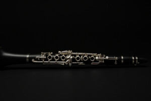 Schwarze Klarinette mit silbernen Klappen auf dunklem Hintergrund