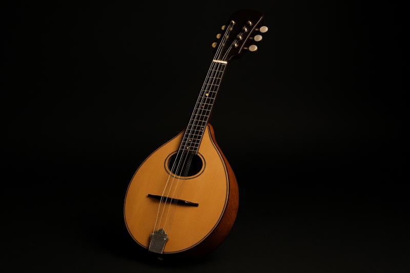 Klassische Mandoline mit ovalem Schallloch und Holzfinish, freigestellt vor schwarzem Hintergrund