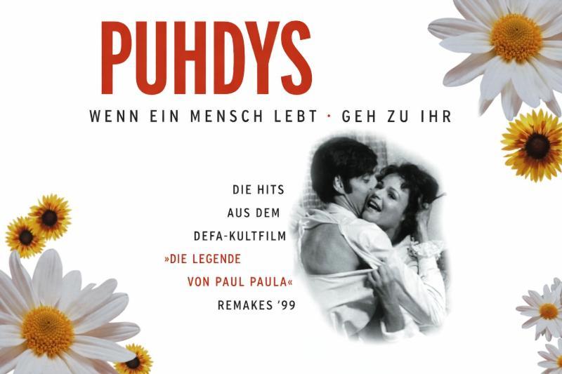 Albumcover der Band Puhdys im 16:9-Format: Oben steht groß „PUHDYS“ in roter Schrift, darunter die Titel „Wenn ein Mensch lebt · Geh zu ihr“. Rechts ist ein schwarz-weißes Bild eines sich umarmenden Paares aus dem Film „Die Legende von Paul und Paula“. Das Design ist mit weißen und gelben Blumen dekoriert, und zusätzlicher Text verweist auf Hits aus dem DEFA-Kultfilm sowie „Remakes ’99“.