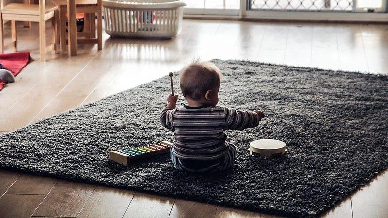 Kleinkind spielt mit Orff-Instrumenten